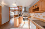 This charming kitchen boasts a warm and inviting atmosphere with its wooden cabinetry and tiled backsplash.