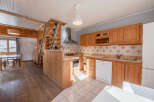 This charming property boasts a cozy kitchen with wooden cabinetry and a modern dishwasher.