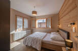 This cozy bedroom features a warm wooden accent wall and a comfortable bed, perfect for a relaxing retreat.