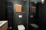 This modern bathroom features sleek black tiles, creating a sophisticated and contemporary ambiance.