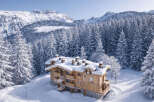 Nestled in a snowy landscape, this stunning wooden chalet offers a luxurious retreat.