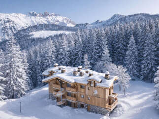 Nestled in a snowy landscape, this stunning wooden chalet offers a luxurious retreat.