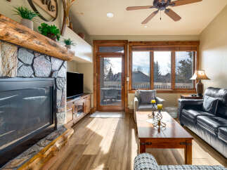 Step into luxury with this stunning living room, featuring a cozy fireplace and a sleek entertainment center.