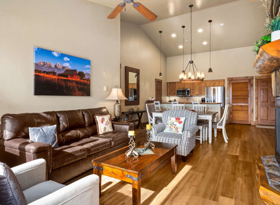 This stunning living space boasts a cozy ambiance with its inviting leather sofa and charming accent pillows.
