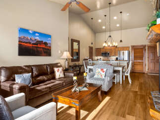 This stunning living space boasts a cozy ambiance with its inviting leather sofa and charming accent pillows.