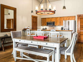 This stunning dining area features a beautiful wooden table and chairs, perfect for family meals or entertaining guests.
