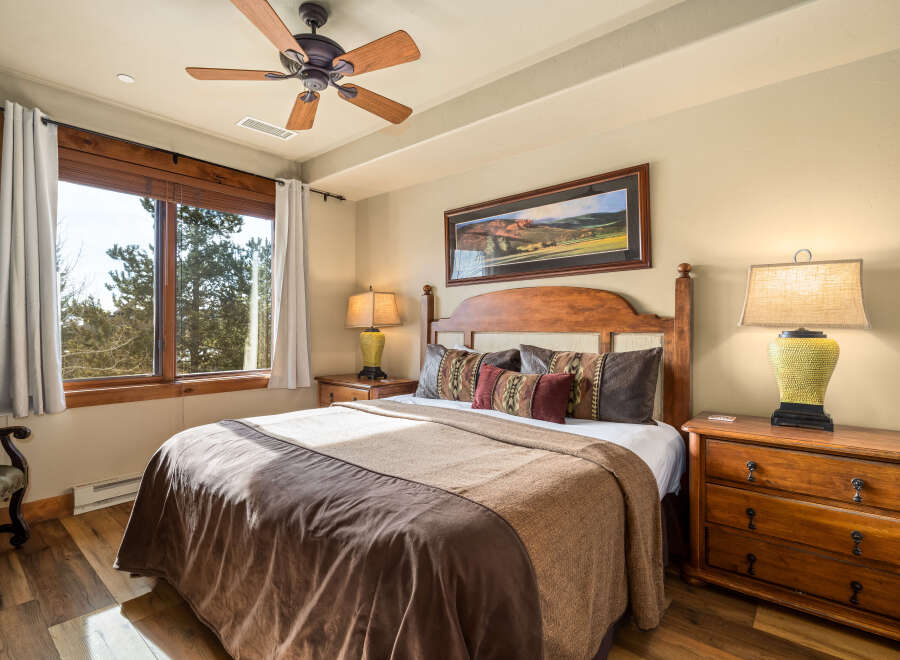 This inviting bedroom boasts a cozy atmosphere with its warm wooden accents and plush bedding.
