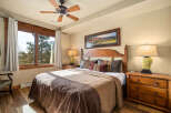This inviting bedroom boasts a cozy atmosphere with its warm wooden accents and plush bedding.
