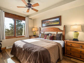 This inviting bedroom boasts a cozy atmosphere with its warm wooden accents and plush bedding.