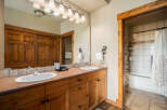 This stunning bathroom boasts a rustic charm with its wooden cabinetry and warm color palette.
