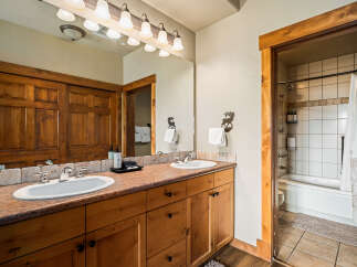 This stunning bathroom boasts a rustic charm with its wooden cabinetry and warm color palette.