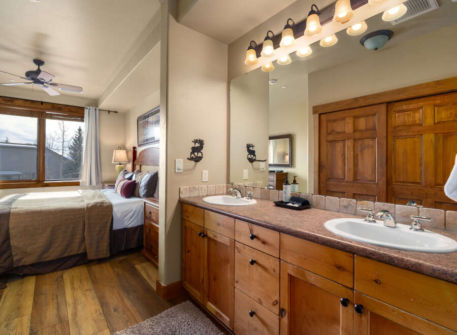 This stunning bathroom features a double vanity with ample counter space and stylish wooden cabinetry.