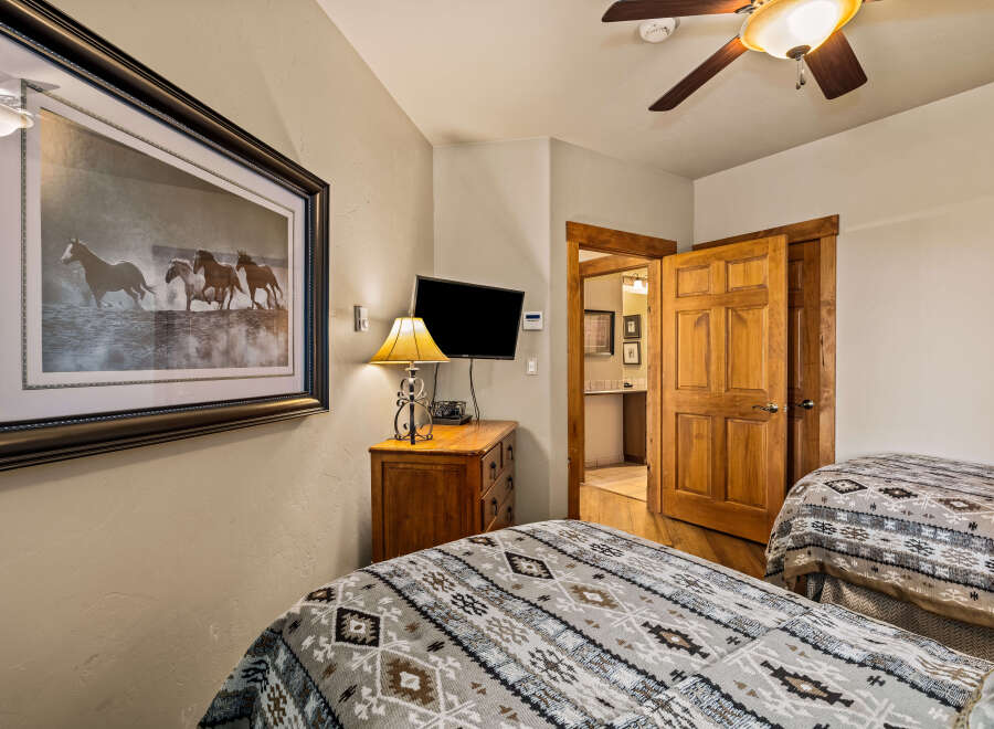 This cozy bedroom features two twin beds with patterned bedding, perfect for guests or family.