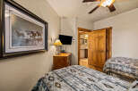 This cozy bedroom features two twin beds with patterned bedding, perfect for guests or family.