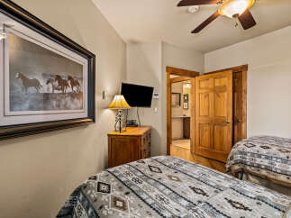 This cozy bedroom features two twin beds with patterned bedding, perfect for guests or family.
