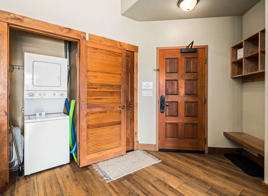 Step into this inviting entryway featuring a stacked washer and dryer, perfect for convenient laundry days.