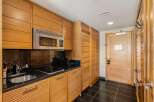 This stunning kitchen boasts sleek, modern design with custom wooden cabinetry and a stainless steel microwave.