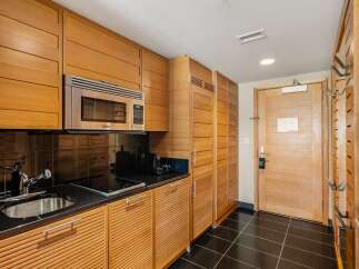 This stunning kitchen boasts sleek, modern design with custom wooden cabinetry and a stainless steel microwave.