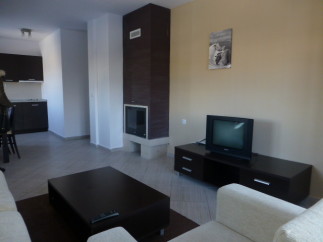 Cozy apartment featuring a modern kitchen, a fireplace for a warm ambiance, and a comfortable living area with a TV.
