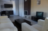 Cozy apartment featuring a comfortable living room with beige sofas and a coffee table, perfect for relaxation.