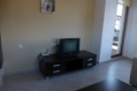 Cozy living room with tiled floors and a dark brown media console featuring a TV and drawers.
