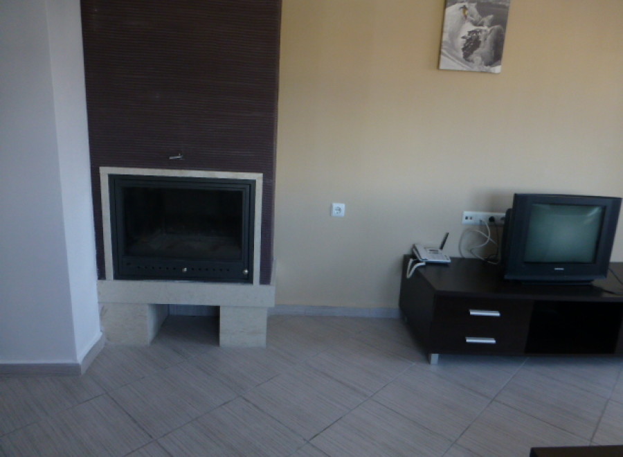 Cozy fireplace and modern TV stand enhance this comfortable living space.