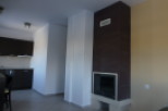 Modern apartment featuring an open-plan kitchen and living area with a stylish fireplace.