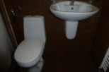 This cozy bathroom boasts a modern toilet and a stylish wall-mounted sink, perfect for a quick refresh.