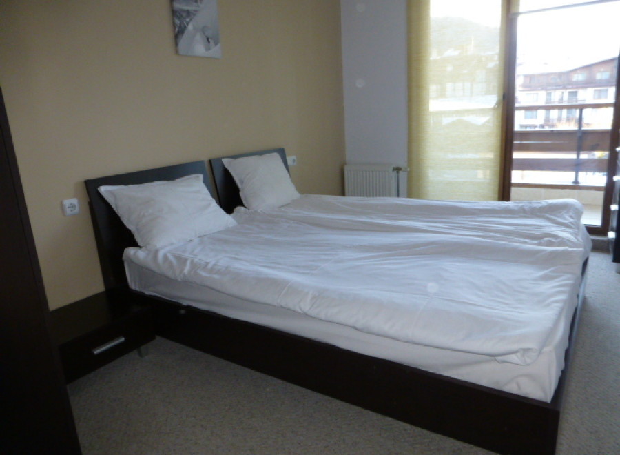 This cozy bedroom features a comfortable double bed with crisp white linens, perfect for a relaxing stay.