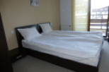 This cozy bedroom features a comfortable double bed with crisp white linens, perfect for a relaxing stay.