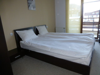This cozy bedroom features a comfortable double bed with crisp white linens, perfect for a relaxing stay.