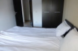 This cozy bedroom features a comfortable double bed with crisp white linens, perfect for a relaxing stay.