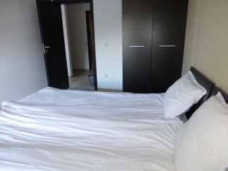 This cozy bedroom features a comfortable double bed with crisp white linens, perfect for a relaxing stay.