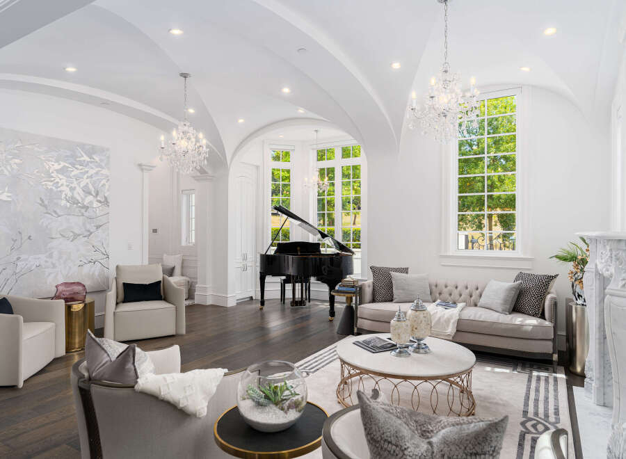 Experience luxury living in this stunning property featuring a grand piano, elegant chandeliers, and a sophisticated living area.