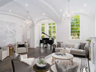 Experience luxury living in this stunning property featuring a grand piano, elegant chandeliers, and a sophisticated living area.