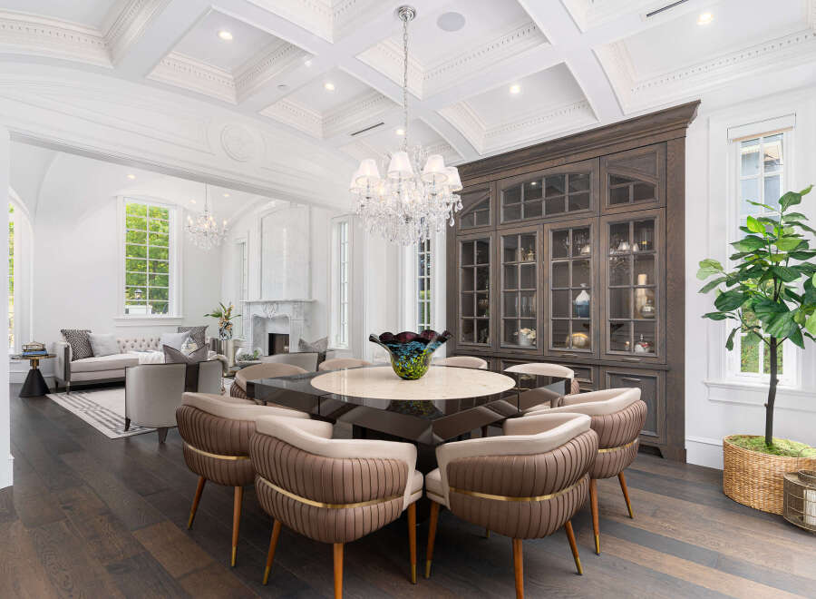 Step into luxury with this stunning dining room, featuring a custom-built cabinet and a beautiful chandelier.