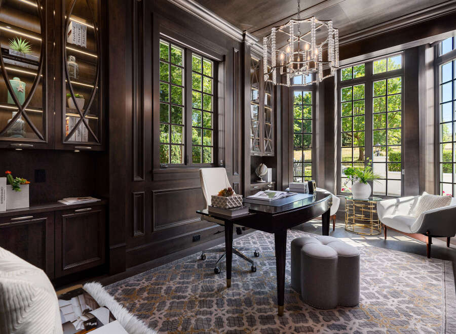 Step into luxury with this stunning home office, featuring rich wood paneling and abundant natural light.