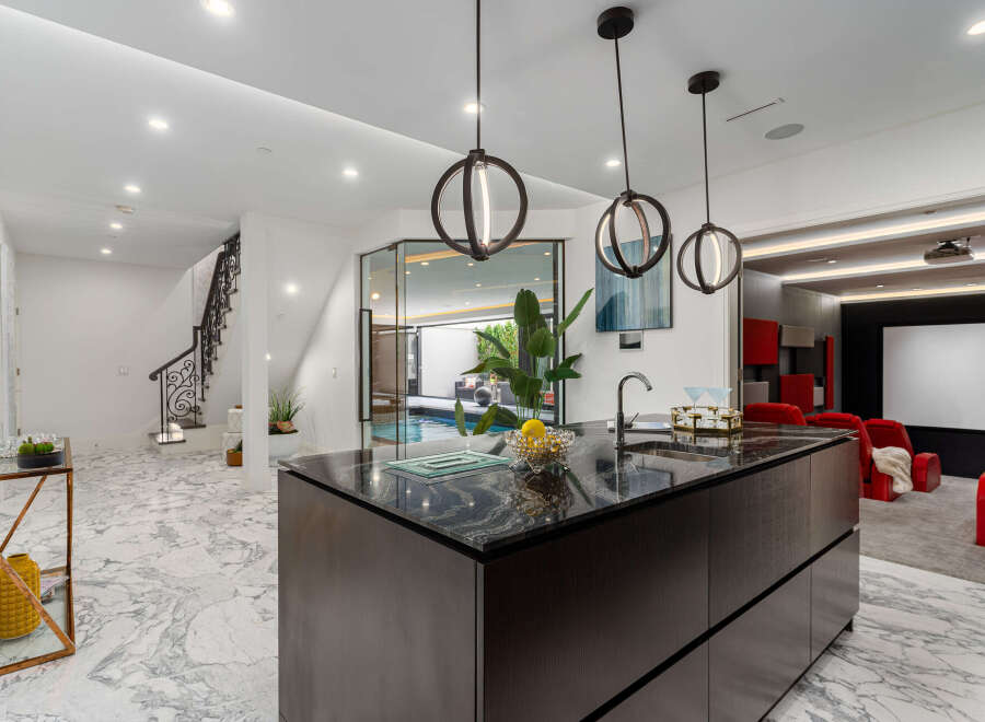 Experience luxury living in this stunning property, featuring a modern kitchen with a sleek island and pendant lighting.