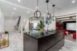Experience luxury living in this stunning property, featuring a modern kitchen with a sleek island and pendant lighting.