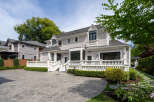This stunning property boasts a beautifully designed exterior with a paved driveway and lush landscaping.