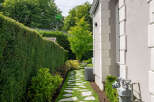 Discover the charm of this beautifully landscaped property, featuring a serene stone pathway that leads through a lush green lawn.