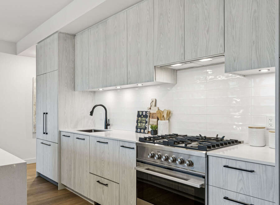 This modern kitchen boasts sleek, light-colored wood cabinetry and a pristine white countertop, creating a bright and inviting space.