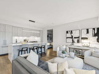 Experience modern luxury in this stunning condo, featuring a sleek kitchen with a breakfast bar and high-end appliances.