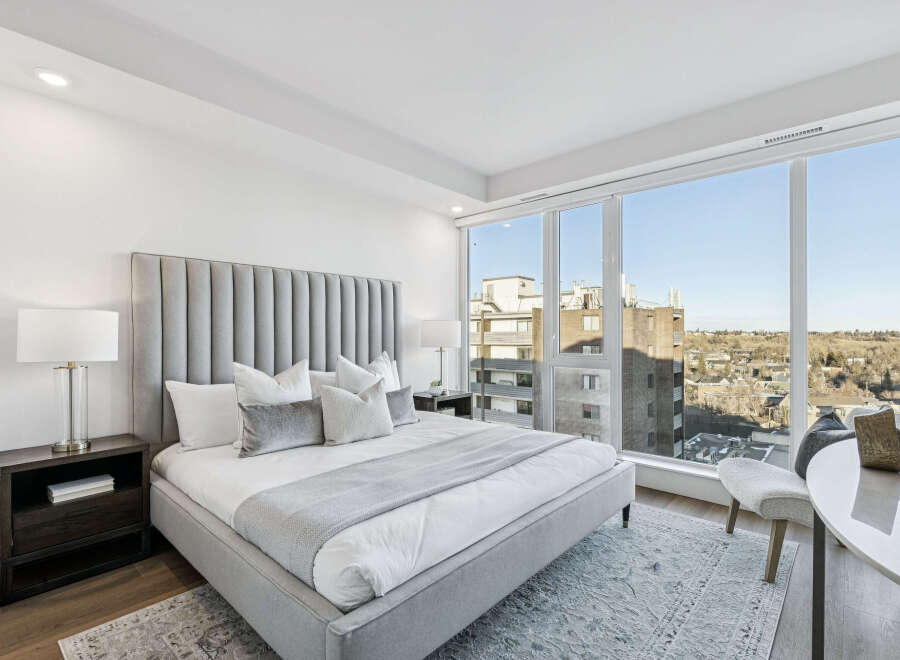Experience luxury living in this stunning bedroom with breathtaking city views.