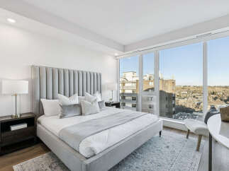 Experience luxury living in this stunning bedroom with breathtaking city views.