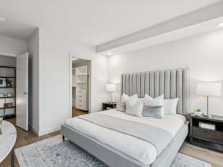 Step into luxury with this stunning bedroom featuring a plush, upholstered headboard and a cozy, inviting bed.