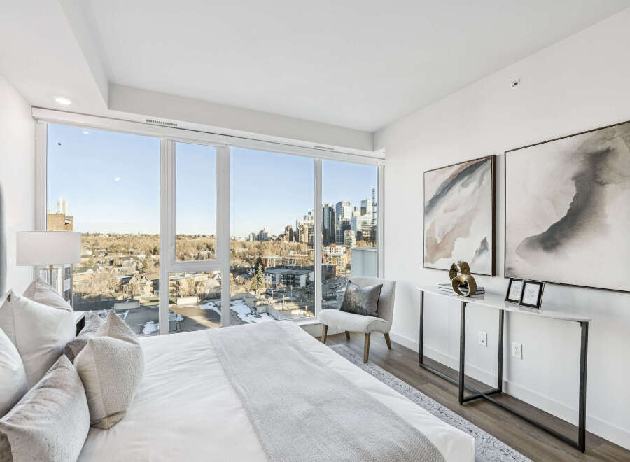 Experience luxury living in this stunning bedroom with breathtaking city views.