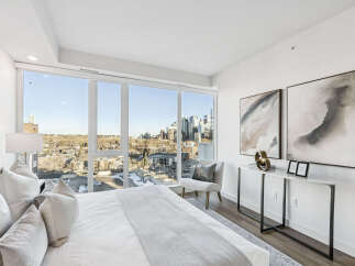 Experience luxury living in this stunning bedroom with breathtaking city views.
