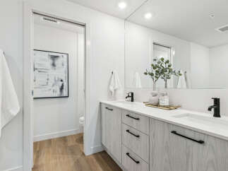 Step into a modern bathroom oasis! This stunning space features a sleek vanity with ample storage, complemented by a large mirror that enhances the natural light.