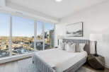 Experience luxury living in this stunning bedroom with breathtaking city views.